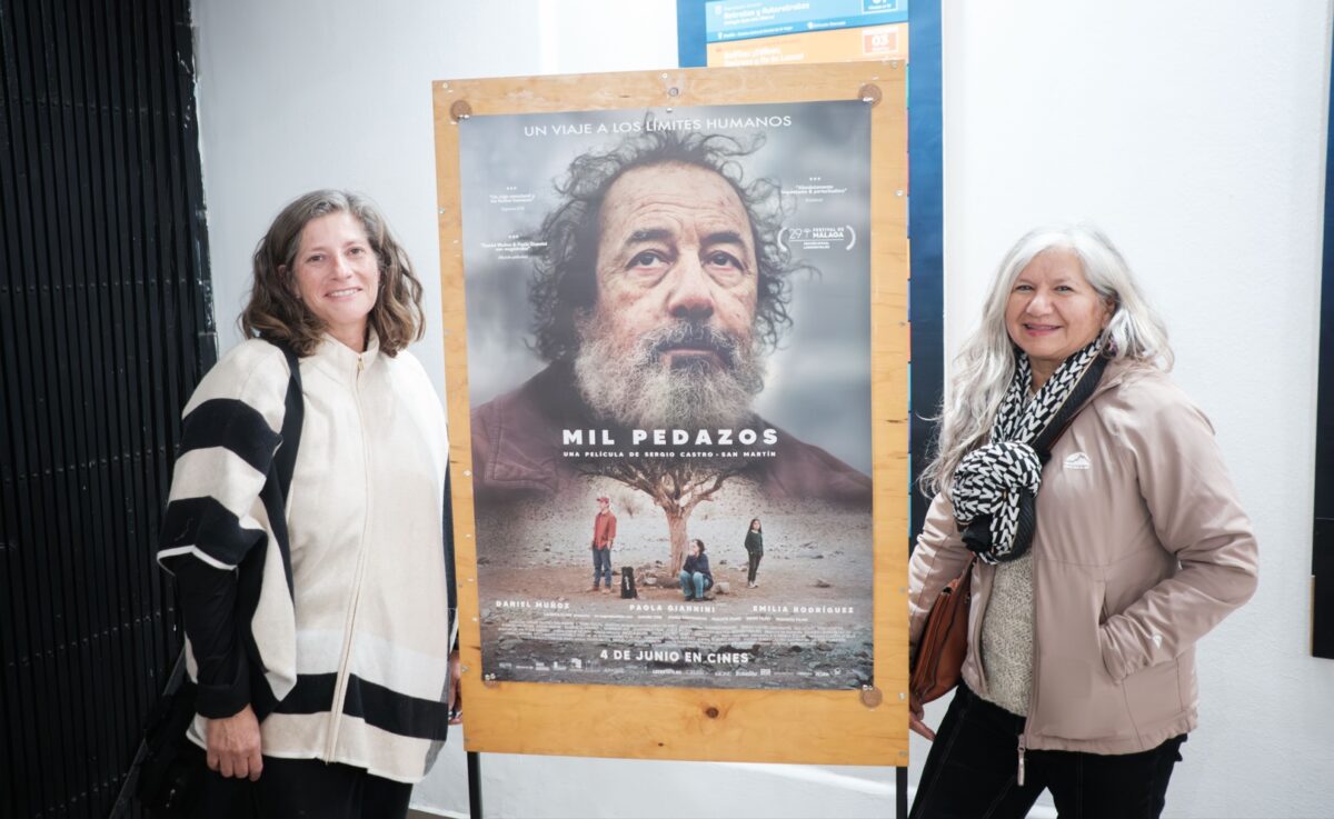 Asistentes junto al afiche de la película Mil pedazos en el Teatro Municipal Pompeya.