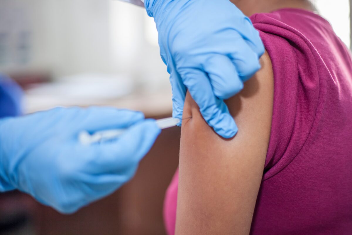Personal de salud aplicando una vacuna en el brazo de un paciente.