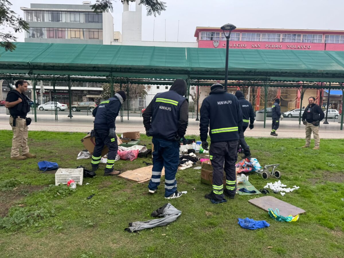 Funcionarios municipales de Valparaíso retirando elementos de la vía pública en una plaza.
