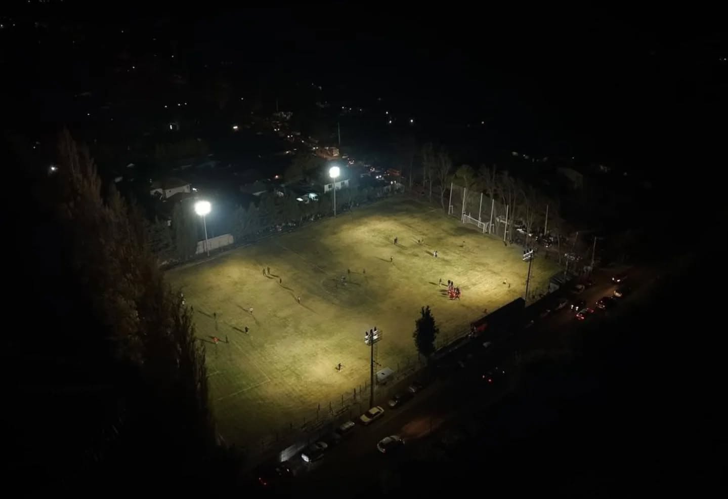Vista aérea nocturna de la cancha de Vichiculén iluminada.