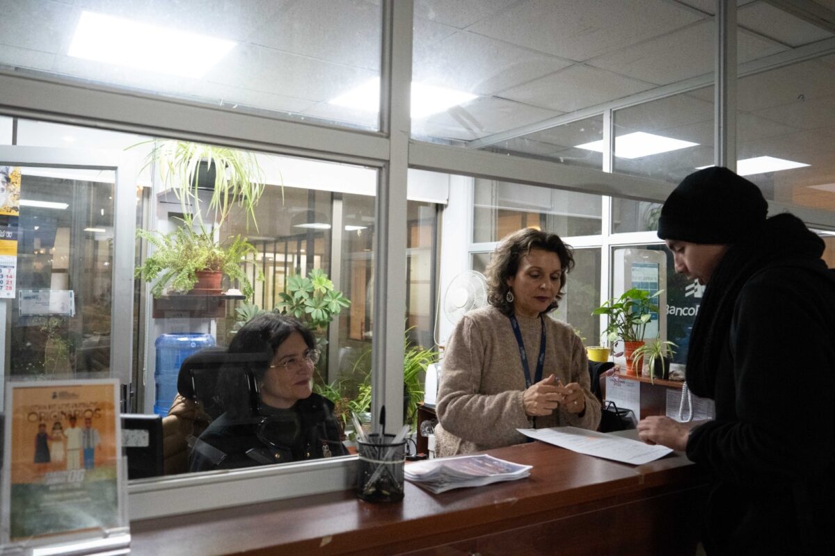 Funcionarias municipales atendiendo a un vecino en un mesón de atención.