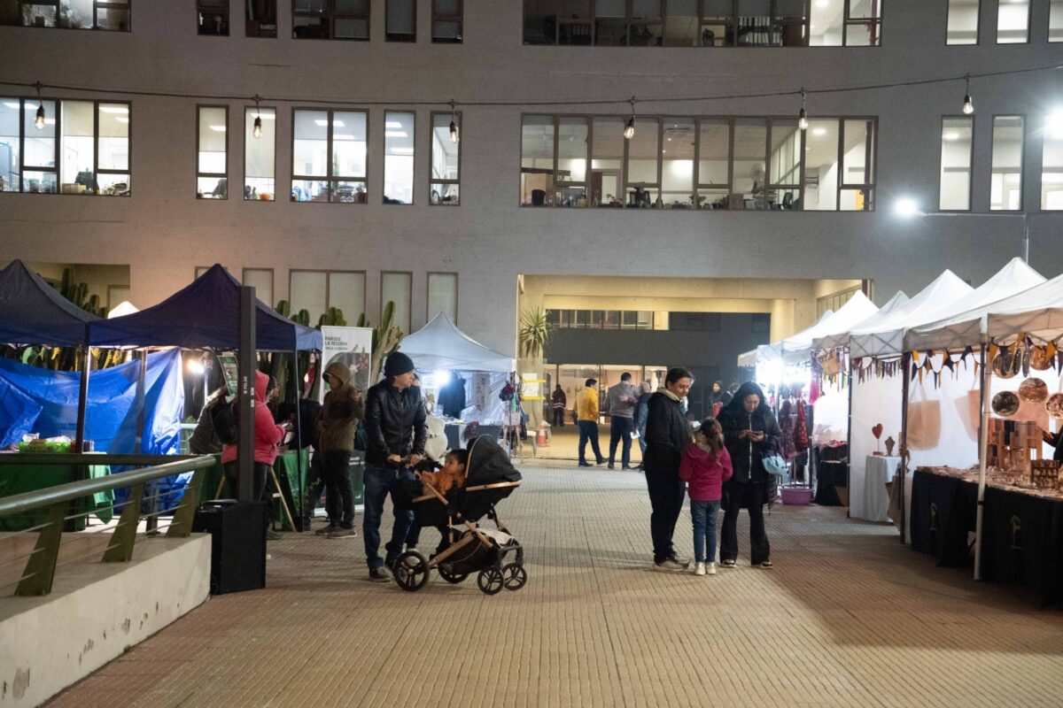 Feria de emprendedores con toldos y personas transitando en el exterior del edificio municipal de Villa Alemana.