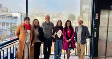 Grupo de profesionales de la salud reunidos en una terraza con vista a Valparaíso.