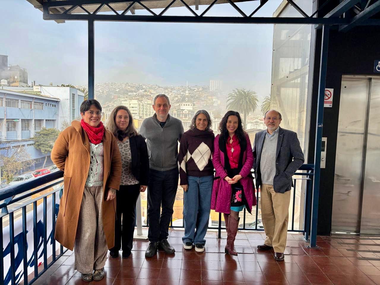 Grupo de profesionales de la salud reunidos en una terraza con vista a Valparaíso.