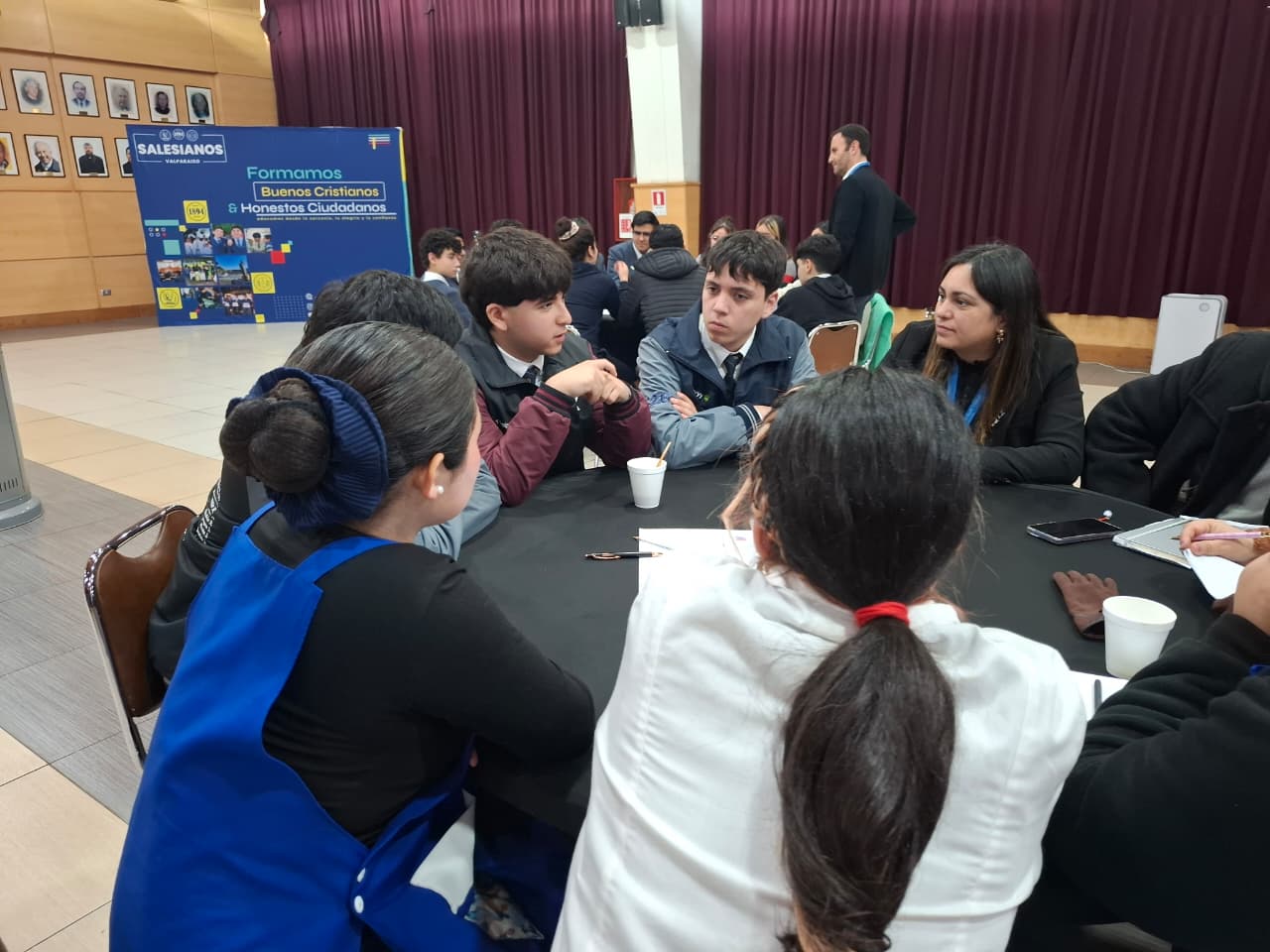 Estudiantes conversando en una mesa durante la Mesa Regional 'Entornos Digitales Seguros'.