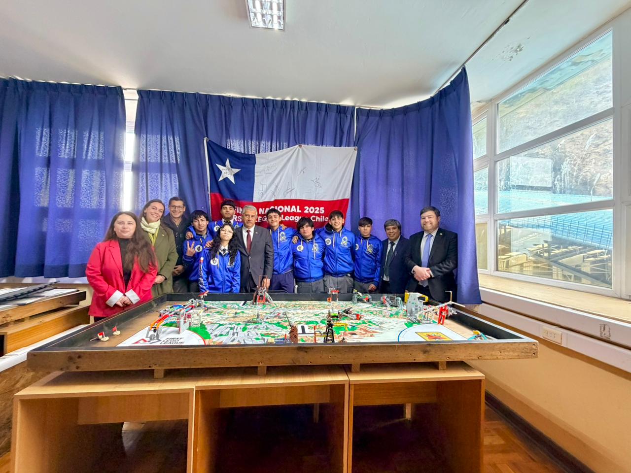 Equipo de robótica R2D2 de la Escuela Industrial Superior de Valparaíso junto a autoridades, frente a un mapa de competencia y una bandera chilena.
