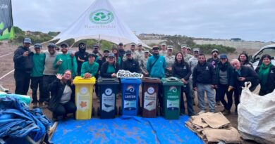 Participantes de la jornada de limpieza en el Humedal Los Juanes con contenedores de reciclaje.