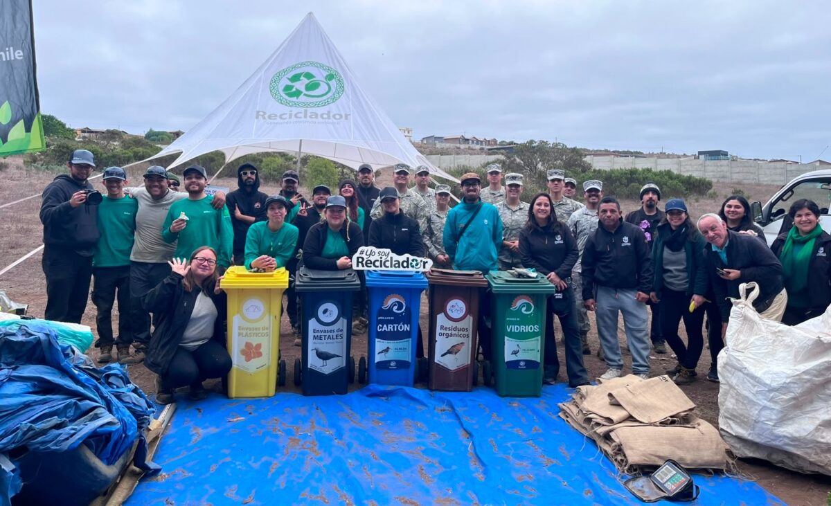 Participantes de la jornada de limpieza en el Humedal Los Juanes con contenedores de reciclaje.