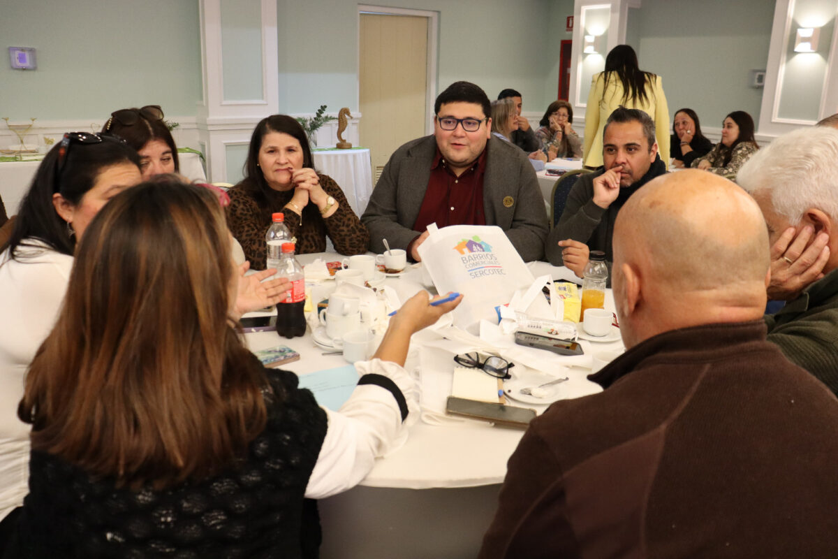 Grupo de comerciantes compartiendo en una mesa durante el encuentro de barrios comerciales.