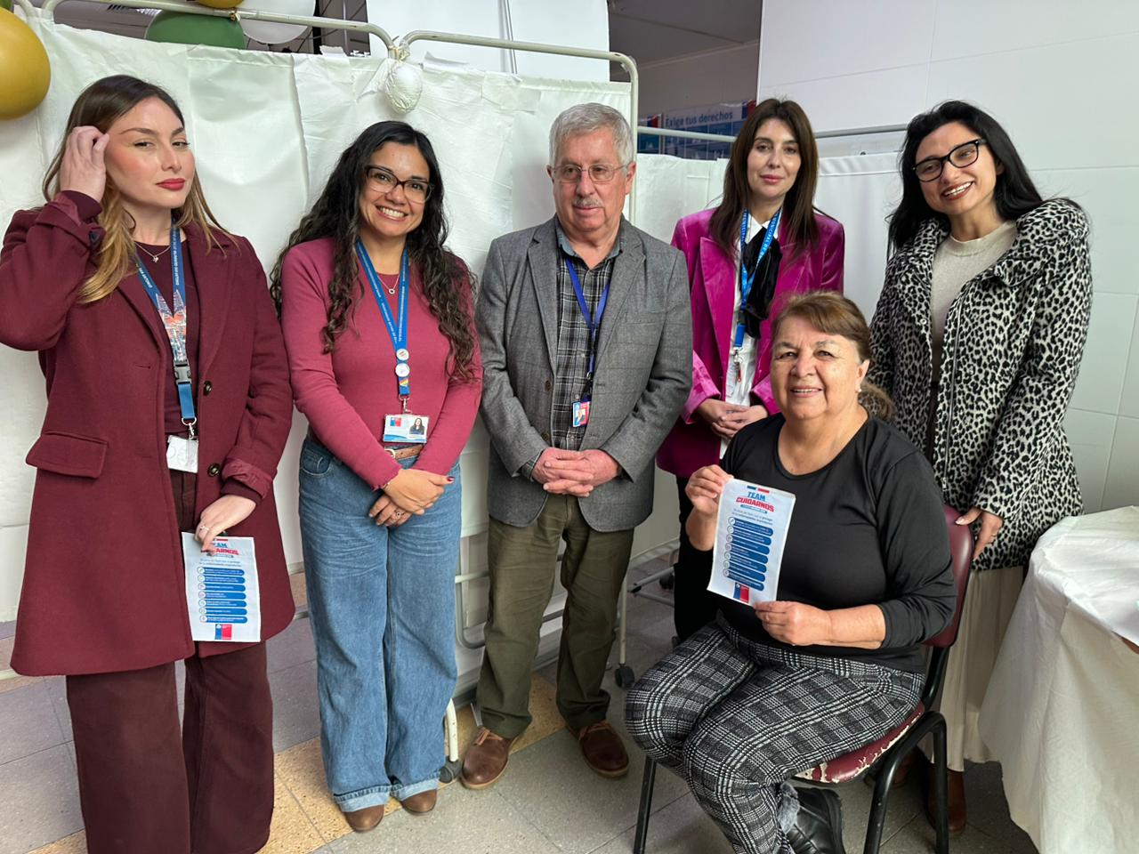 Grupo de autoridades y personal de salud junto a una usuaria en el Cesfam de Quilpué.