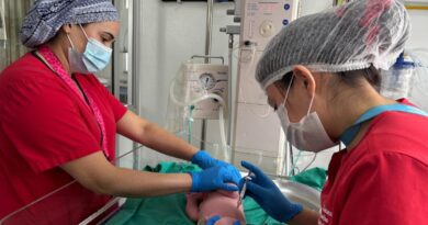 Profesionales de la salud inmunizando a un recién nacido.