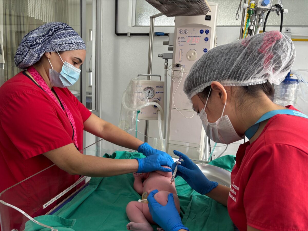 Profesionales de la salud inmunizando a un recién nacido.