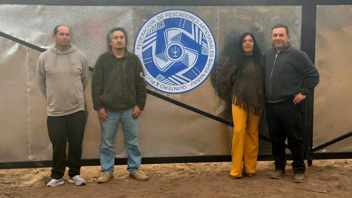 Dirigentes de la Federación de Pescadores de Bahía Narau junto al logo de su organización.