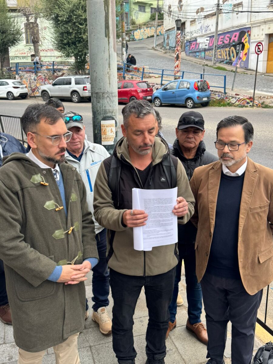 Pescadores y abogado revisando documentos frente a la Contraloría Regional.
