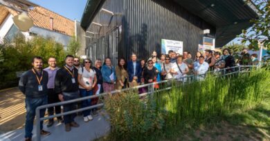 Grupo de personas posando frente a un edificio moderno, celebrando el inicio de los proyectos sociales en San Pedro.