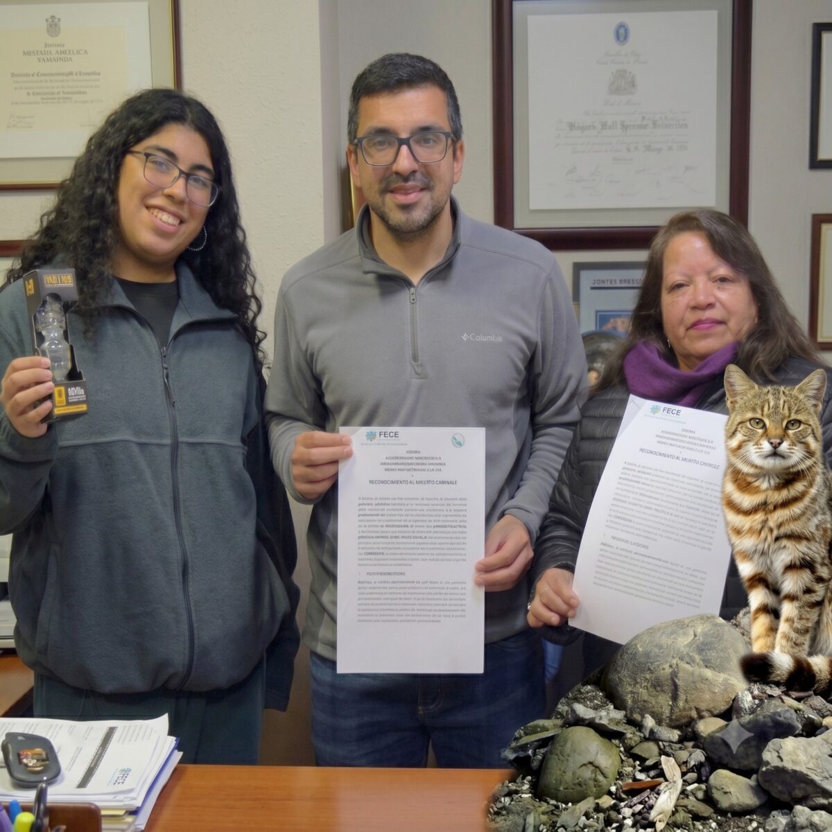 Personas mostrando documentos de convenio para la conservación del gato Colocolo en Llay Llay.