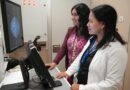 Dos profesionales de la salud observando una pantalla con imágenes mamarias.