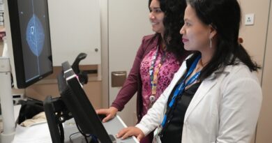 Dos profesionales de la salud observando una pantalla con imágenes mamarias.