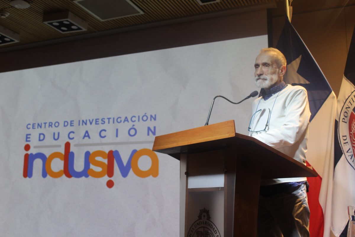 Dr. Lupicinio Iñiguez-Rueda hablando en un atril frente a una pantalla con el logo del Centro de Investigación para la Educación Inclusiva.