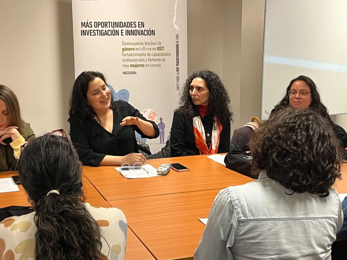 Grupo de mujeres participando en una reunión o charla en la Universidad Santo Tomás.