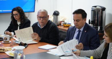 Personas sentadas alrededor de una mesa revisando documentos.