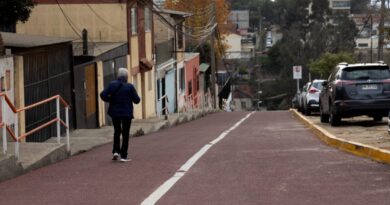 Persona caminando por la calle de acceso al Cesfam Esperanza, Valparaíso, que presenta un nuevo tratamiento de alta fricción.