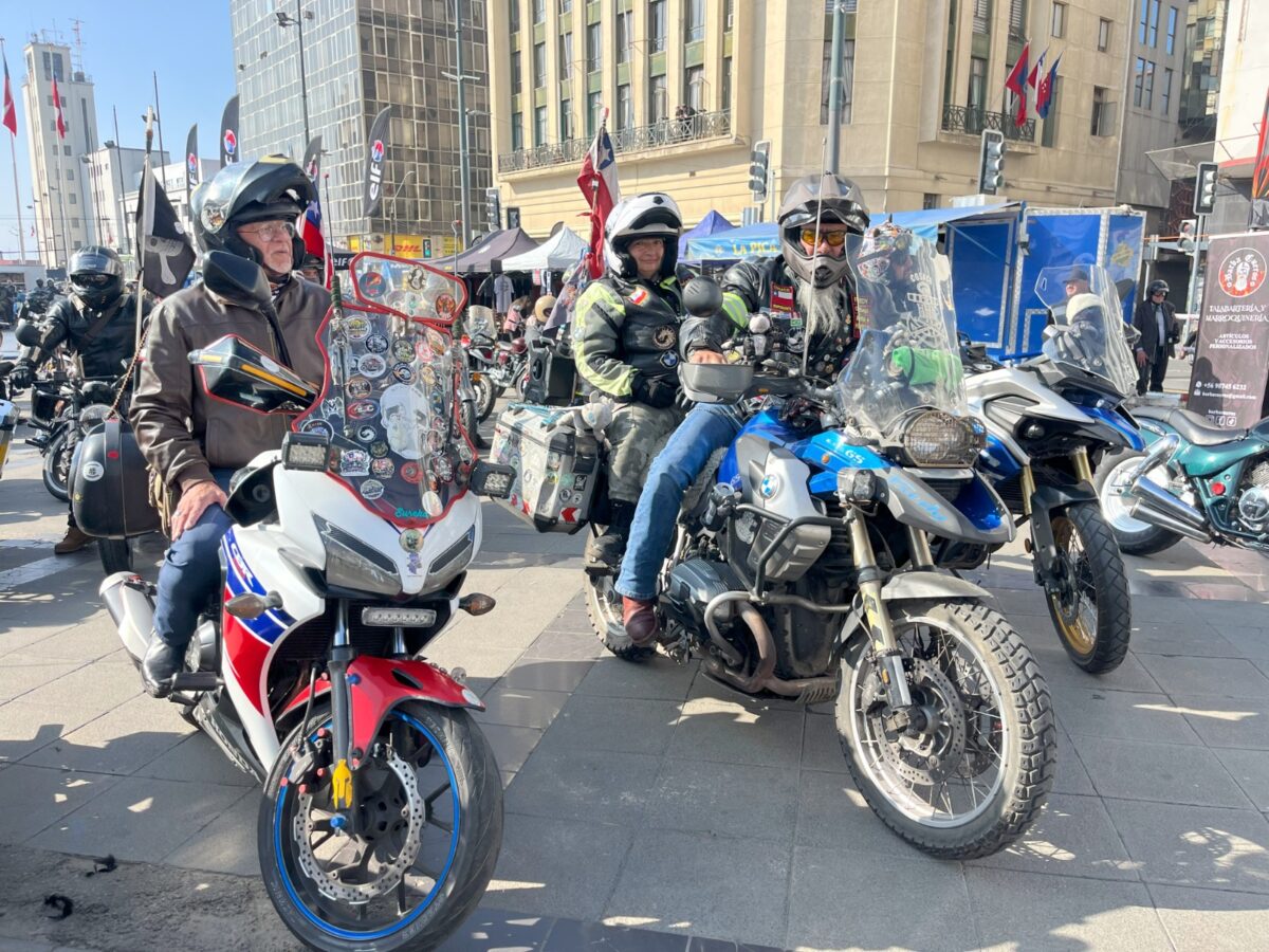 Motociclistas con cascos y equipo de protección sentados en sus motocicletas.