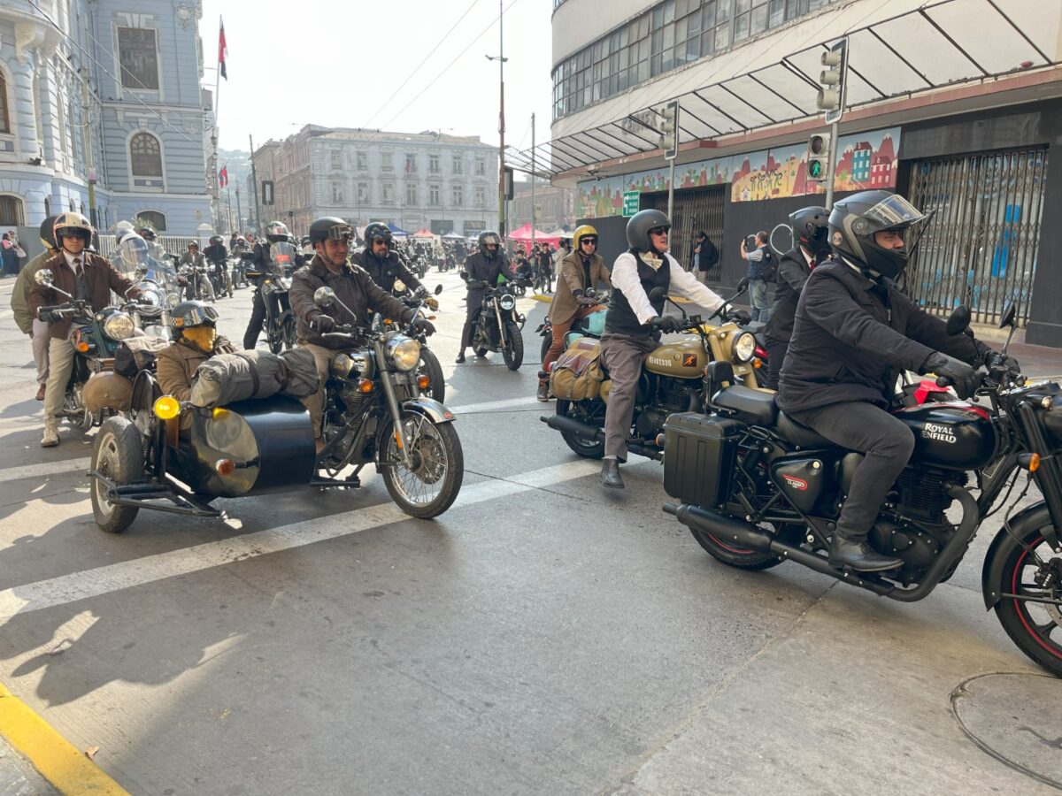 Grupo de personas posando frente a un cartel con temática de motociclismo y prevención de salud.