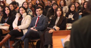 Participantes sentados en un seminario, con un hombre en traje en primer plano.