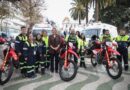 Grupo de personas junto a dos ambulancias y tres motos de emergencia.