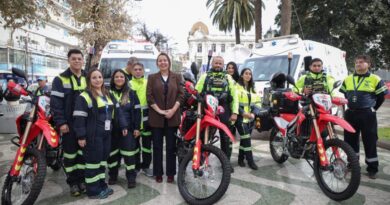Grupo de personas junto a dos ambulancias y tres motos de emergencia.