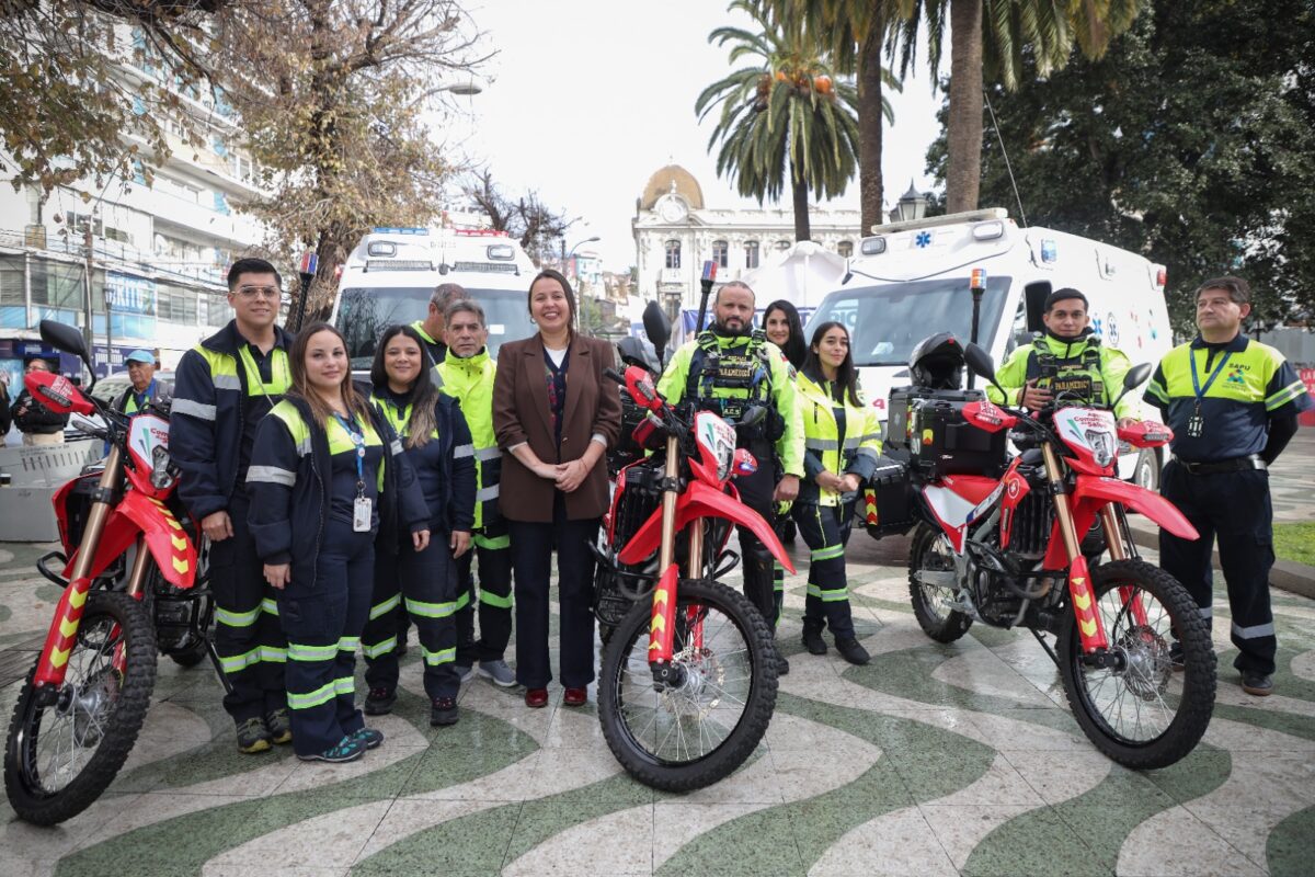 Grupo de personas junto a dos ambulancias y tres motos de emergencia.