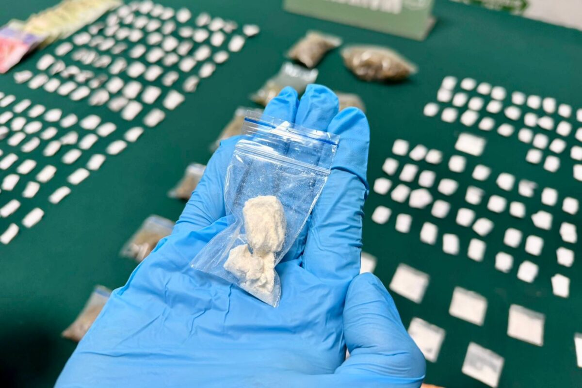 Un guante azul sostiene una bolsa con pasta base de cocaína incautada.