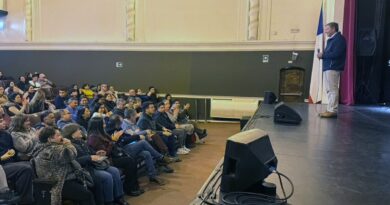 Alcalde Nelson Estay dirigiéndose a un público reunido en un teatro.