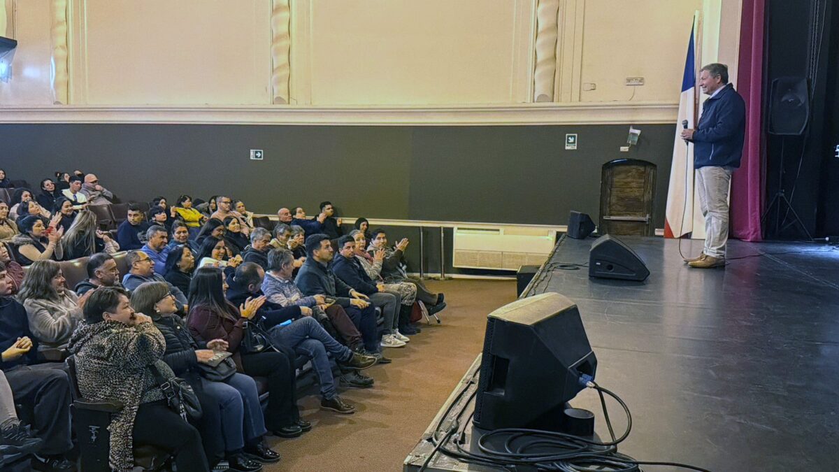 Alcalde Nelson Estay dirigiéndose a un público reunido en un teatro.