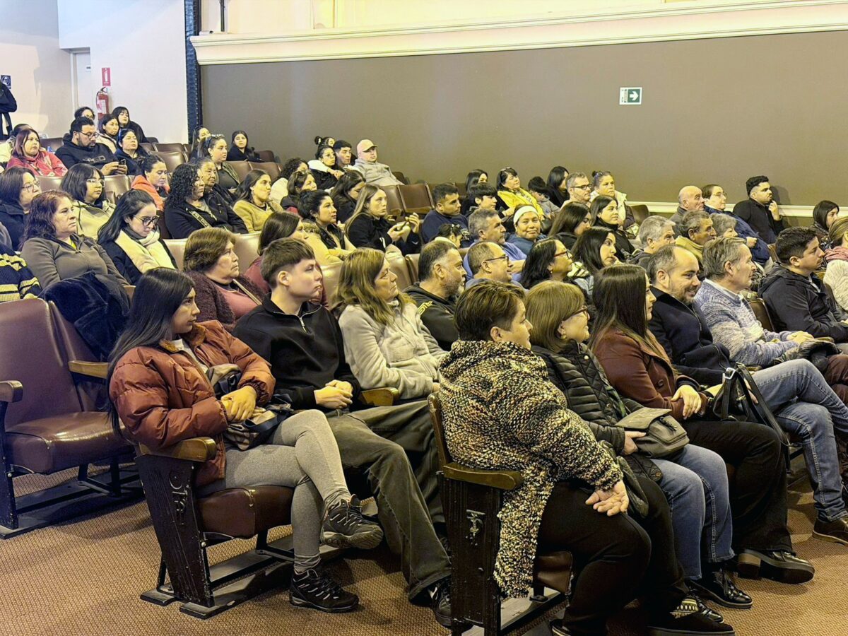 Audiencia sentada en un teatro, escuchando atentamente.