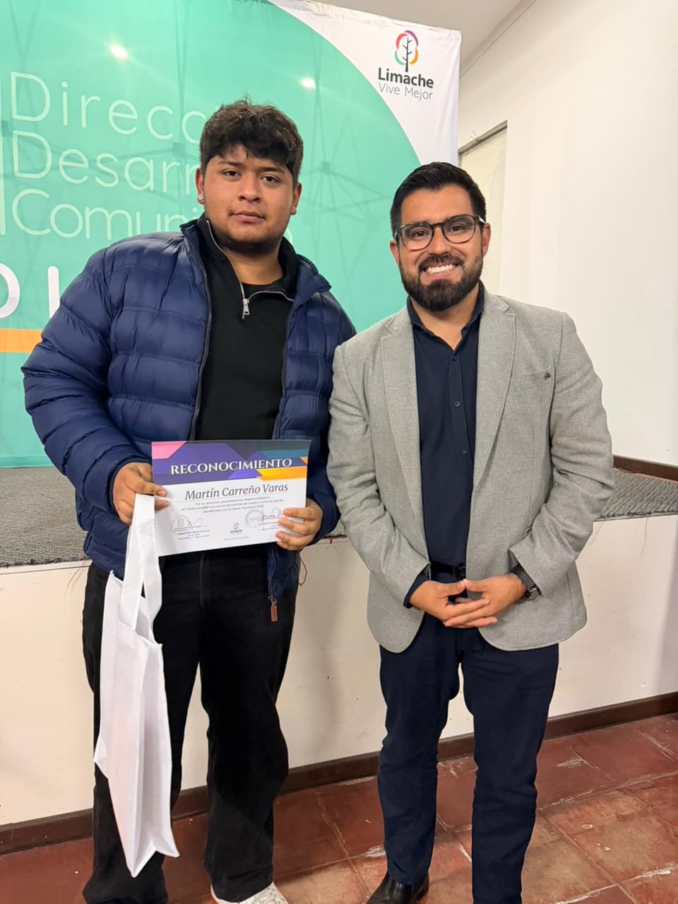 Estudiante recibe su reconocimiento de beca de manos del alcalde de Limache.