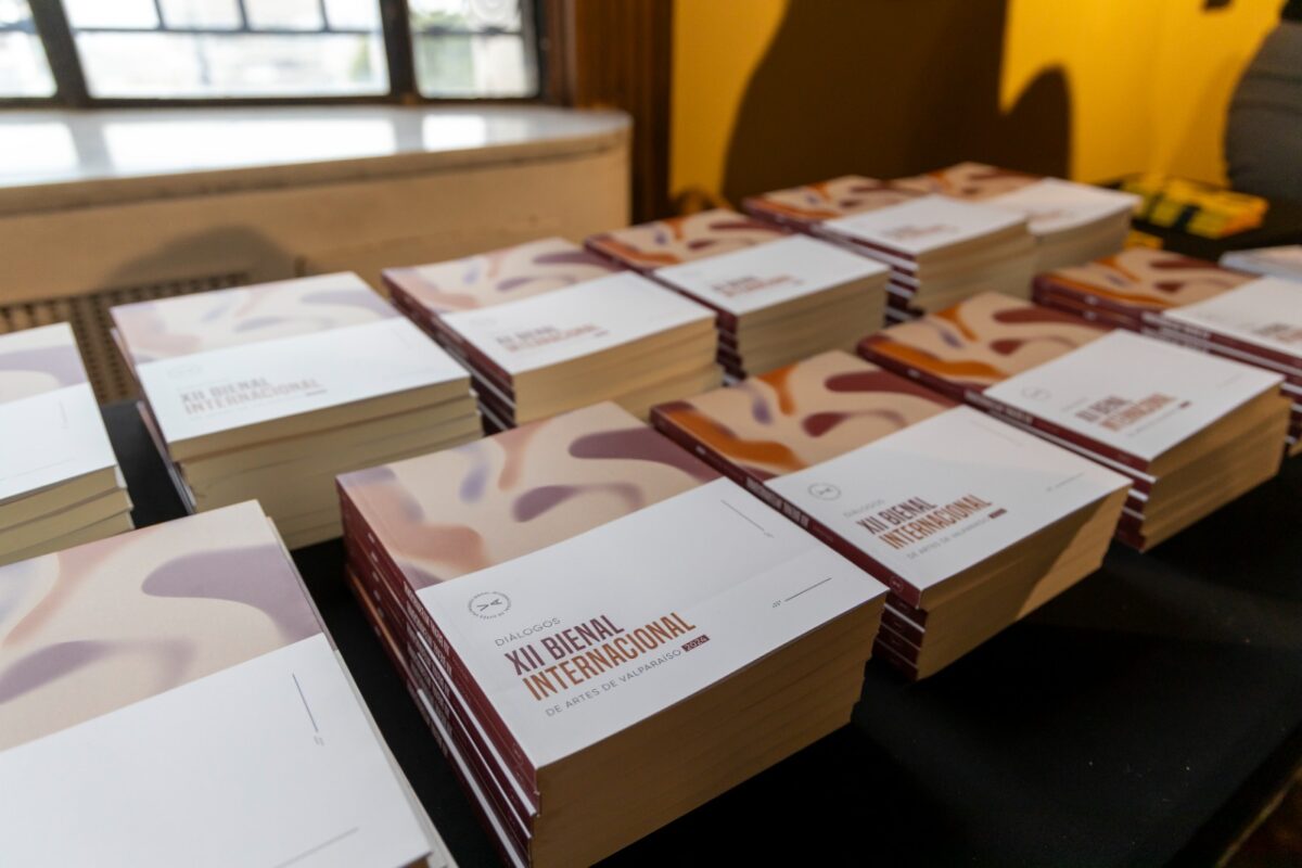 Pilas de folletos o catálogos de la XIII Bienal Internacional de Artes de Valparaíso.