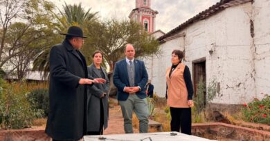 Autoridades observan una tumba o monumento en el exterior de la Iglesia San Francisco de Curimón, con la torre de la iglesia al fondo.