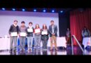 Estudiantes reciben certificados en un escenario durante el Torneo de Debates.
