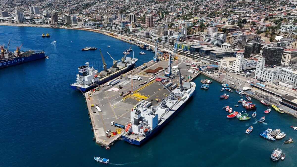Vista aérea del Puerto Valparaíso con buques en el muelle y la ciudad de fondo.