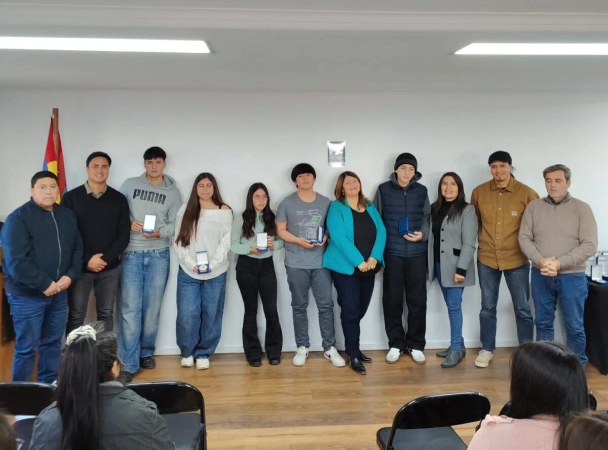 Grupo de estudiantes recibiendo reconocimientos y medallas de parte de autoridades municipales en una ceremonia.