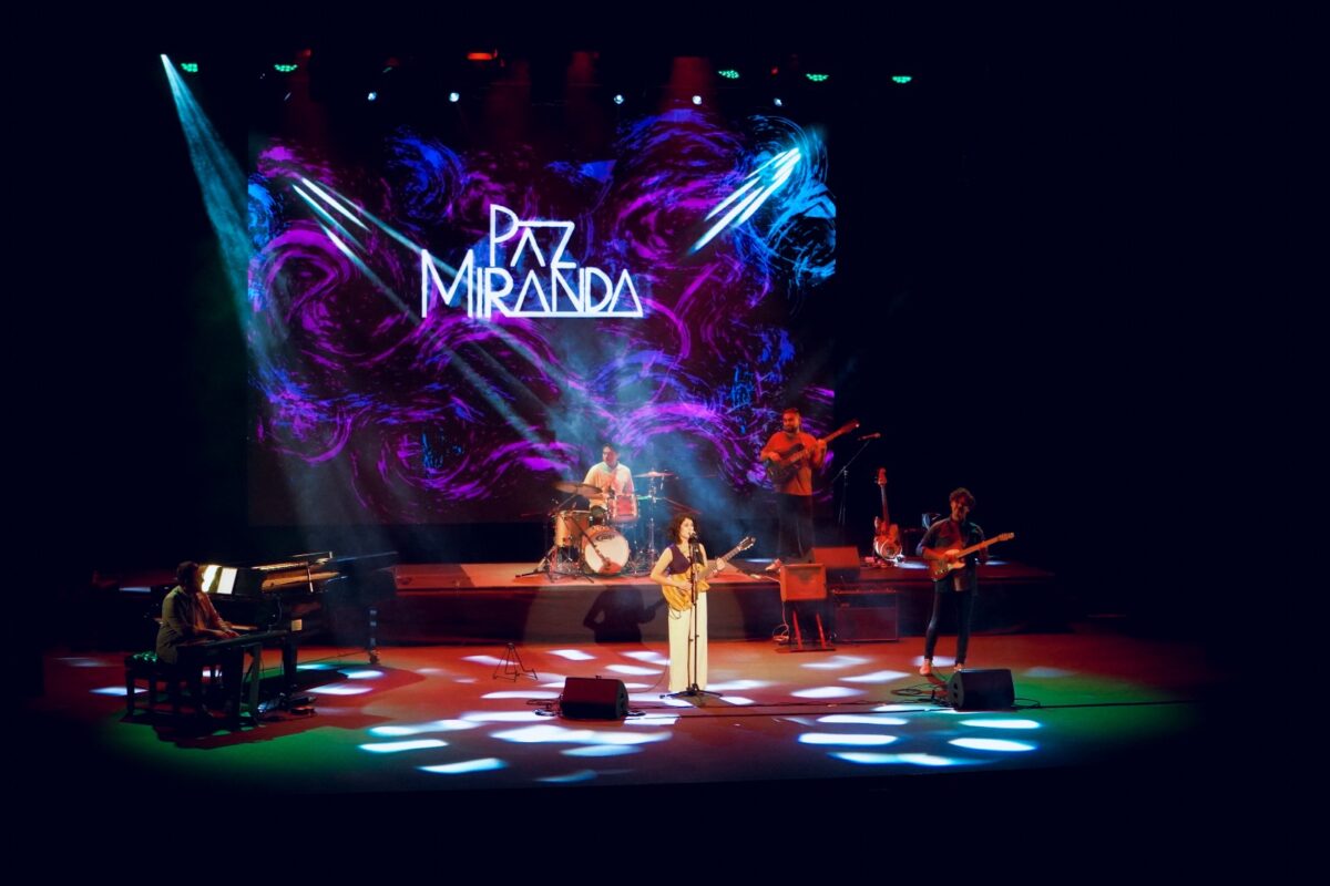 Paz Miranda actuando en un escenario con su banda.