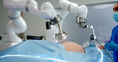 Cirujano observa a un robot quirúrgico asistiendo en una operación laparoscópica.