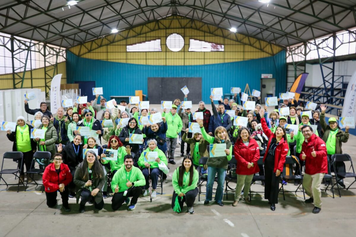 Grupo de personas mayores de Zapallar posando con sus diplomas de reconocimiento en el Gimnasio de Catapilco.