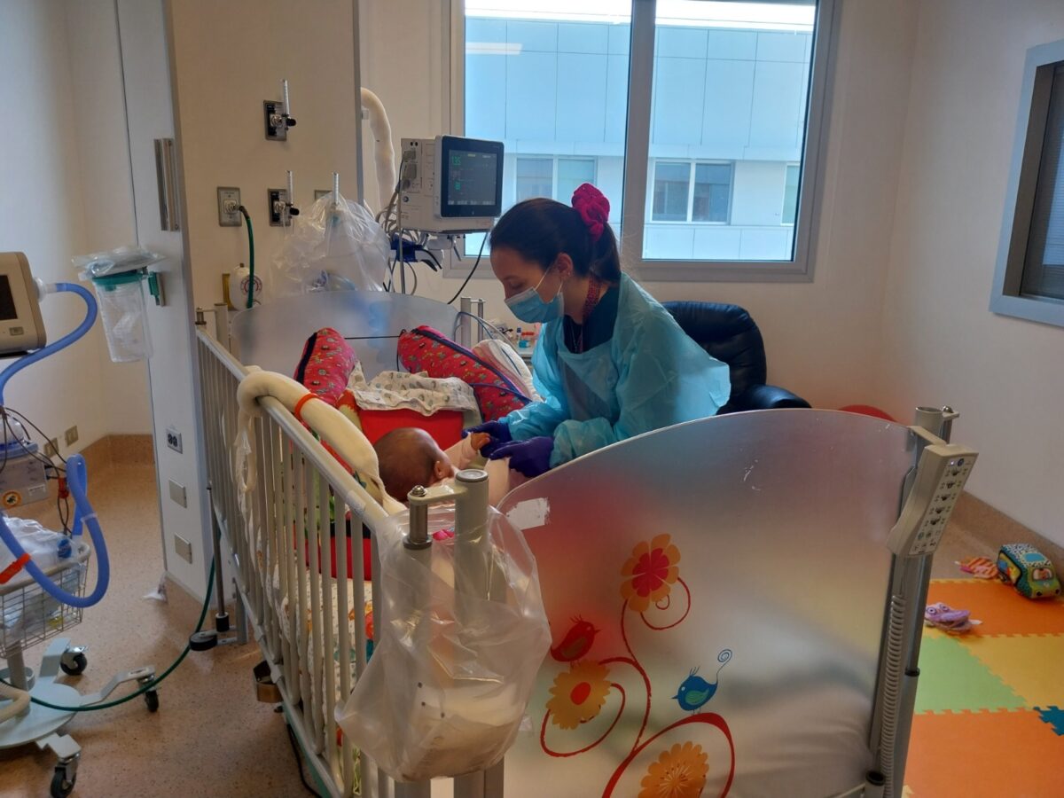 Funcionaria de salud asiste a un pequeño paciente hospitalizado en el marco de la Campaña de Invierno.