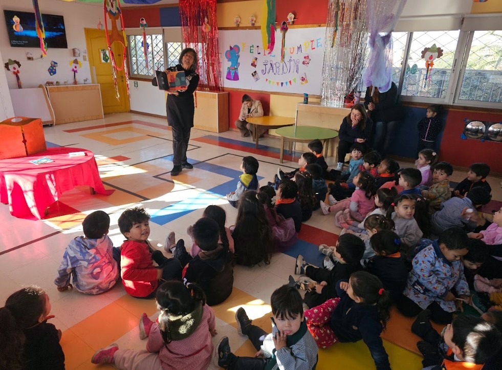 Niños sentados prestando atención a una lectura de cuentos en el aula.