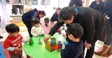 Niños y autoridades interactuando con juegos didácticos en el Jardín Infantil Pequeño Paraíso.