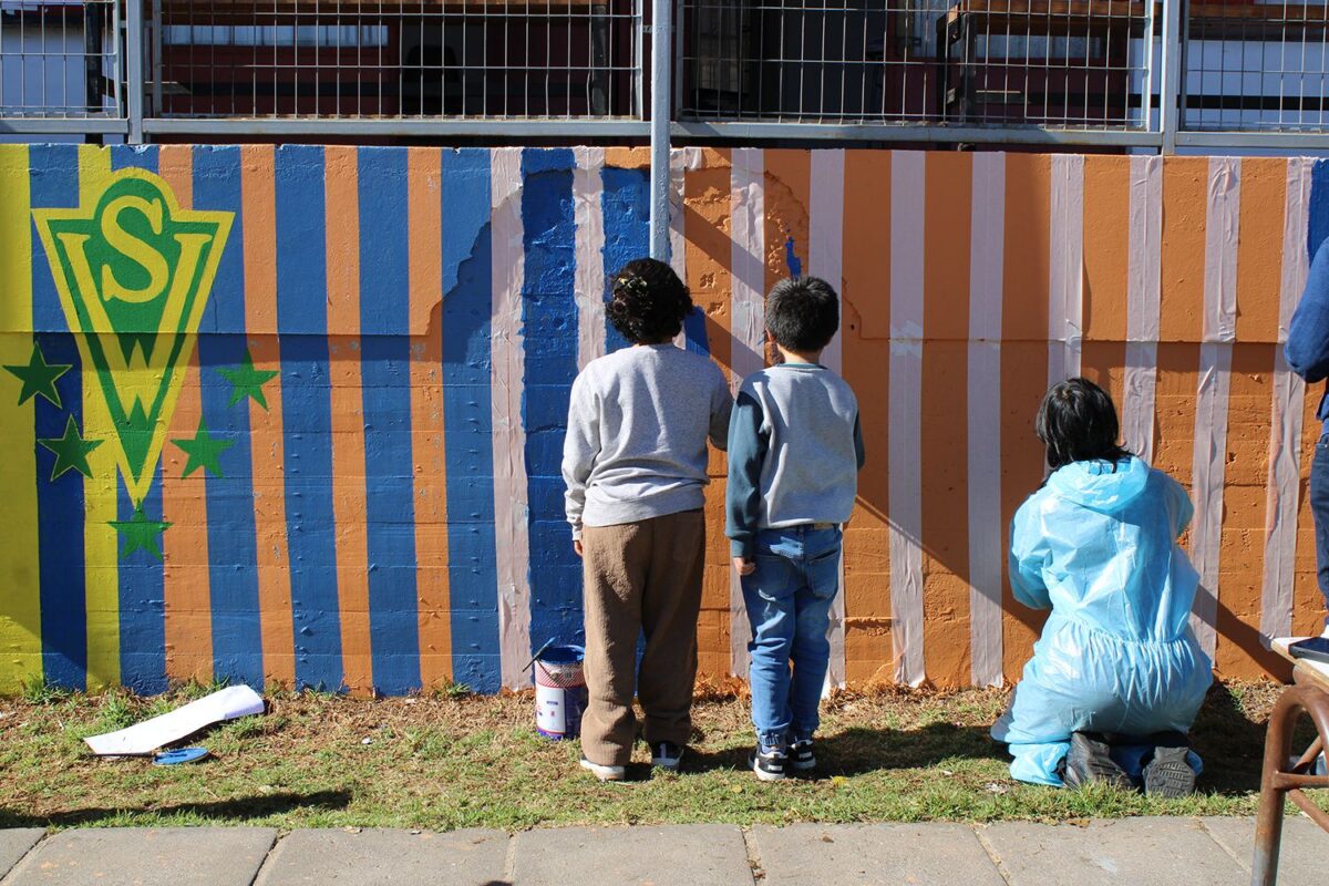 Estudiantes pintando el mural colaborativo en la Escuela Diego Portales