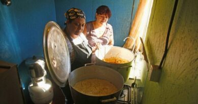 Dos mujeres preparando alimentos en ollas comunes en un sector vulnerable.